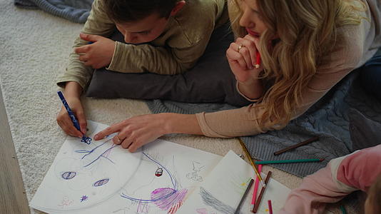 母亲和孩子躺在地毯上画素描视频的预览图