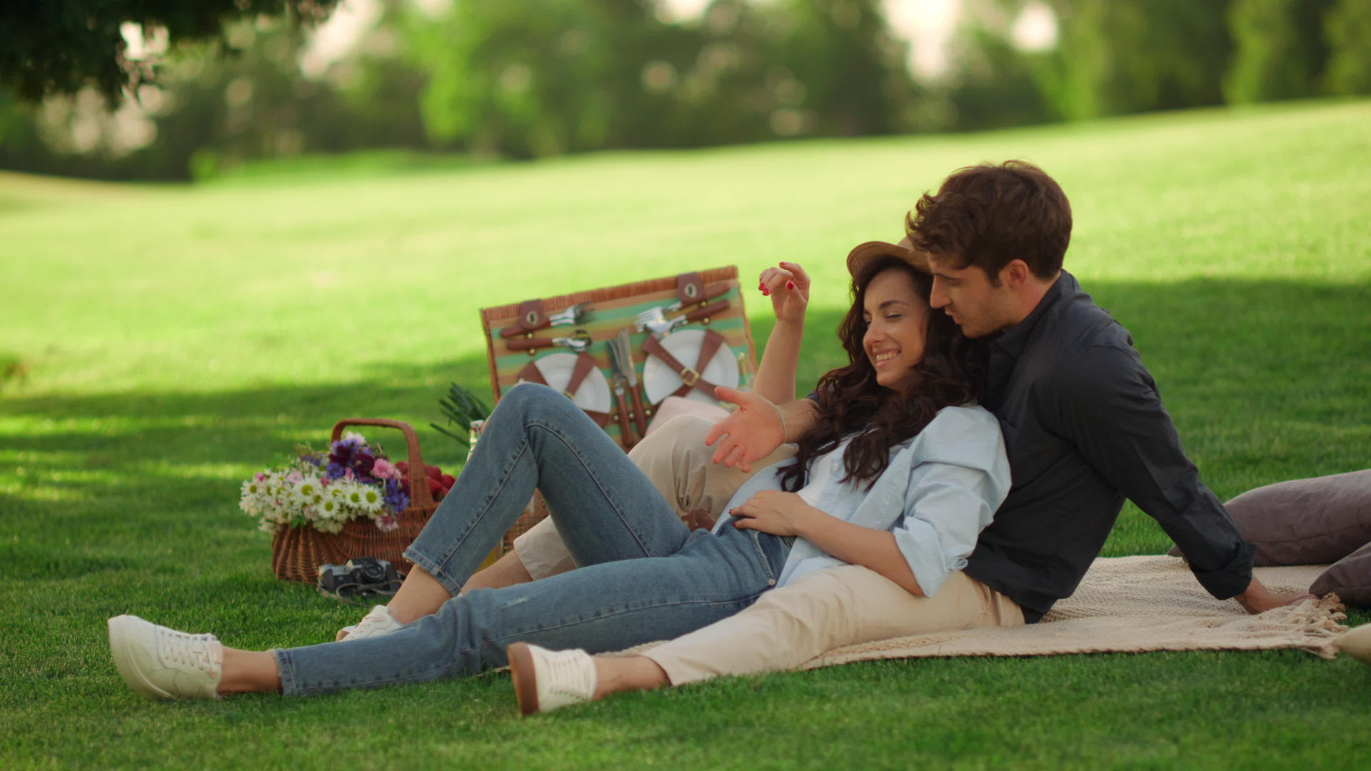 年轻男女坐在公园的毯子上视频的预览图