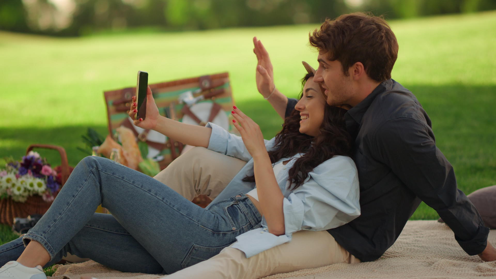 快乐的女孩和男人在公园里打视频电话视频的预览图