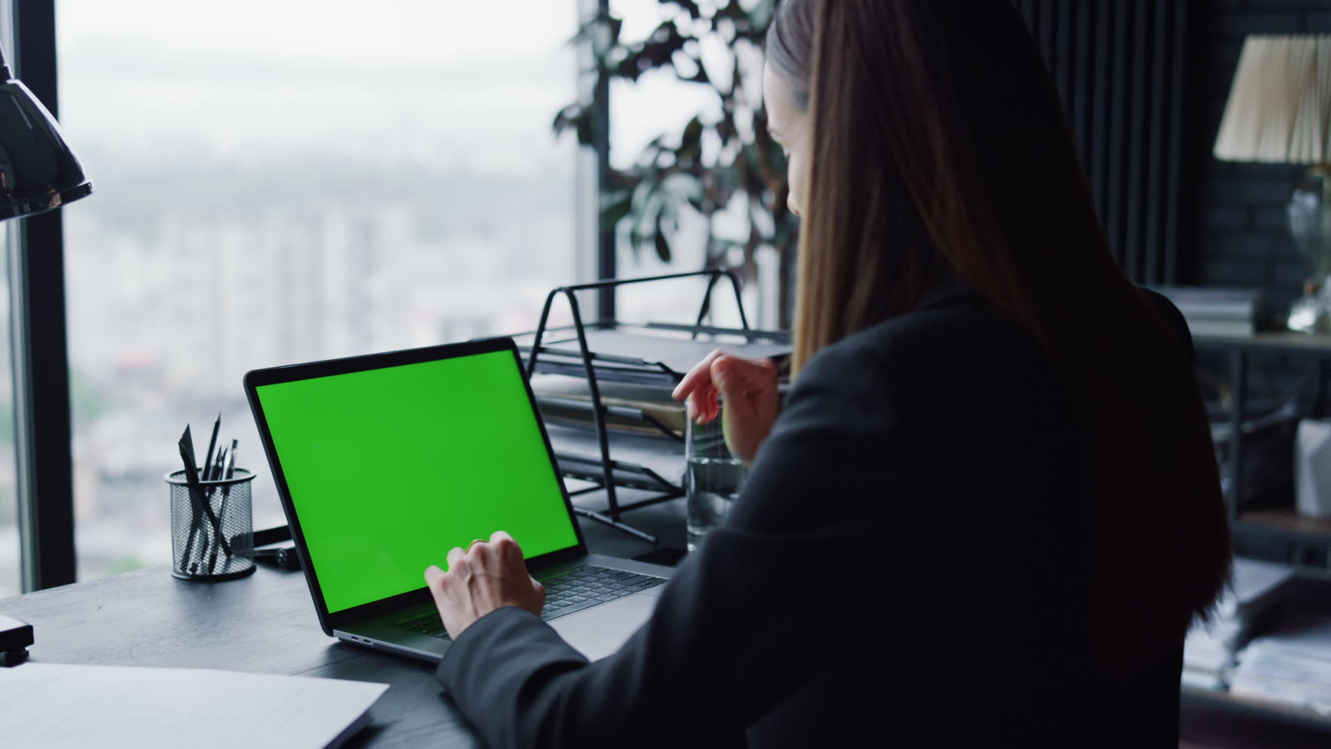 自信的女商人在办公室用绿色屏幕在笔记本电脑上打视频电话视频的预览图