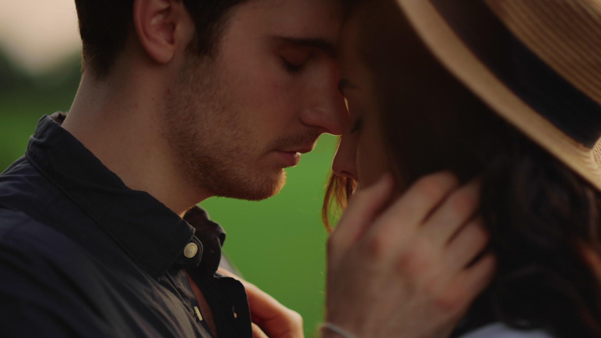 日落时分一对热恋情侣站在草地上视频的预览图