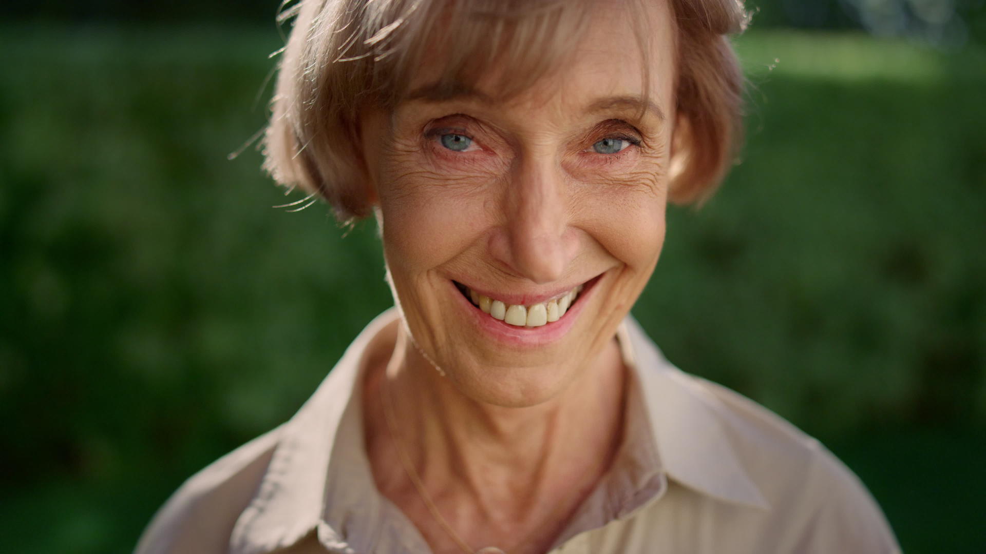 在绿色公园微笑的老太太老奶奶老女性面部特写视频的预览图