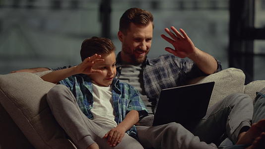 父亲和孩子正在用电脑打电话和其他人聊天视频的预览图
