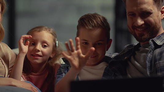 父母和孩子在电脑上和别人开视频视频的预览图