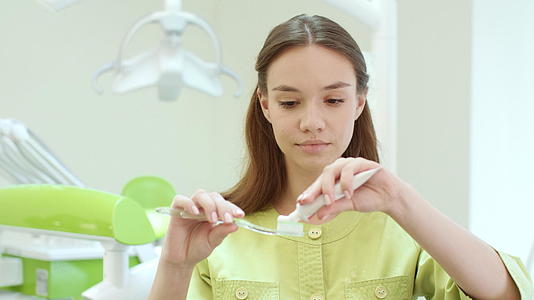 漂亮的女孩在牙刷上挤牙膏视频的预览图