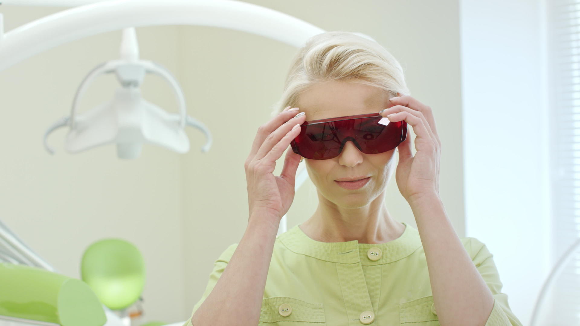 美丽的女士牙医戴着紫外线橙色安全护目镜视频的预览图