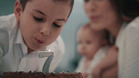 男孩在生日蛋糕上吹蜡烛视频的预览图