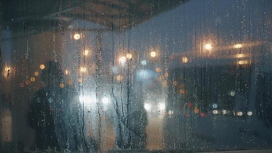 雨季夜晚公交车站台玻璃水珠视频的预览图