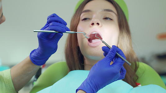 用牙科工具检查病人牙齿的女医生视频的预览图