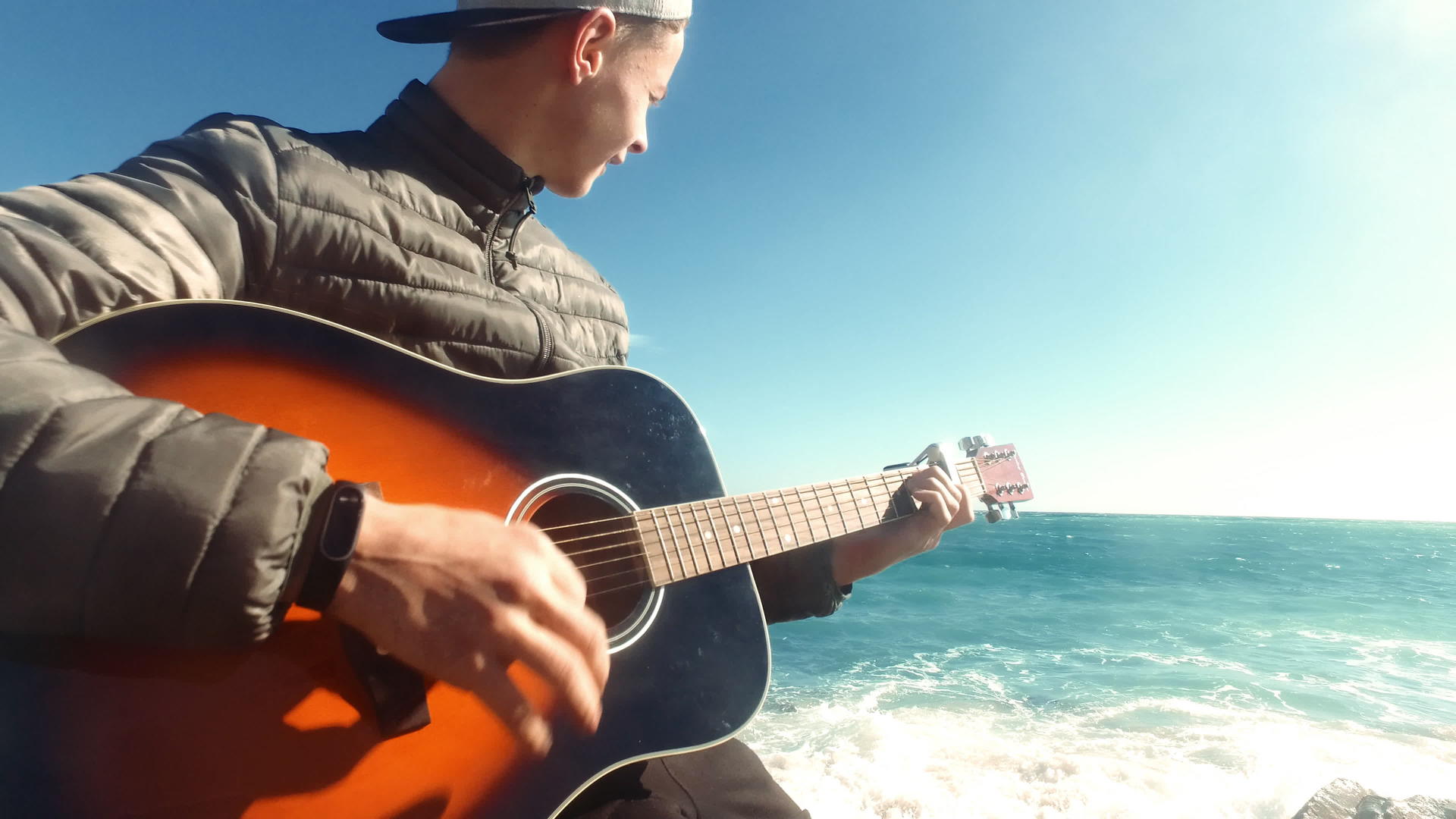 快乐的男孩在海滩上弹吉他视频的预览图