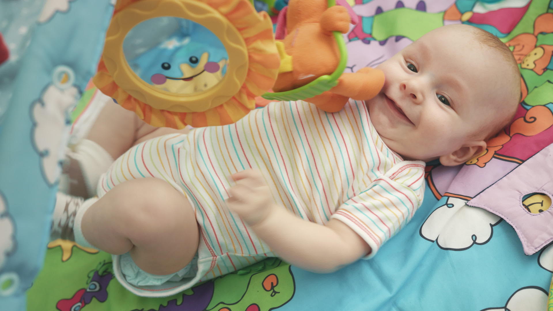 快乐的婴儿躺在五颜六色的垫子上视频的预览图