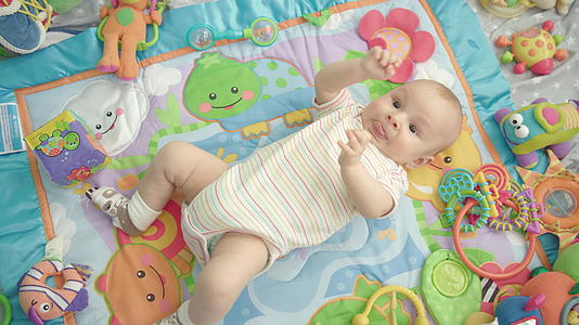 小宝躺在五颜六色的地毯上视频的预览图