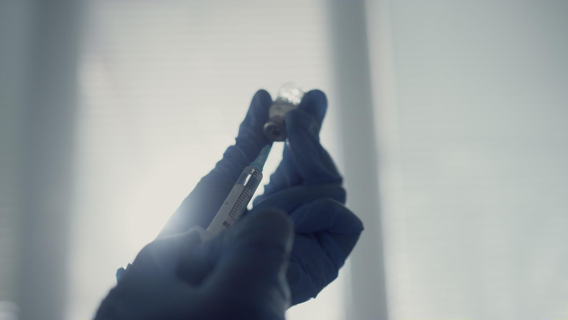 医生用一小瓶抗病毒药物填充注射器视频的预览图