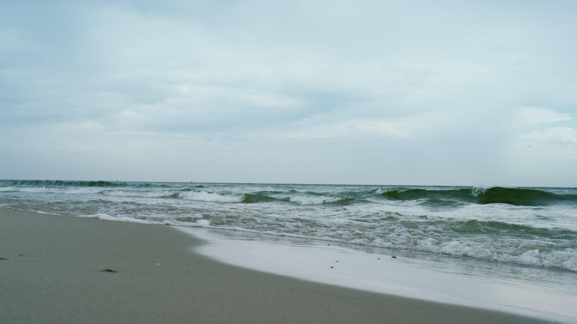 海浪在灰色多云的天气中撞击海滩视频的预览图