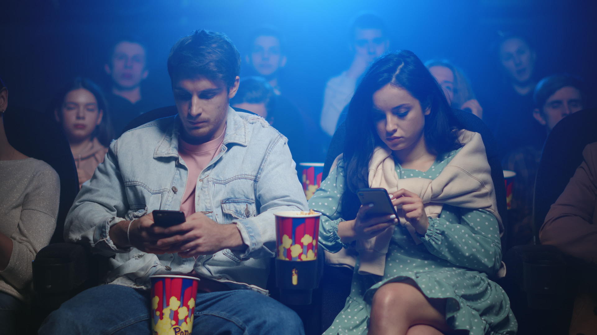 年轻夫妇在电影院看手机视频的预览图