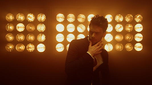 性感的男模特在灯光下自信地摆姿势视频的预览图