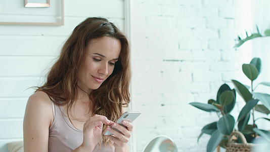 女性在家用手机查看信息视频的预览图