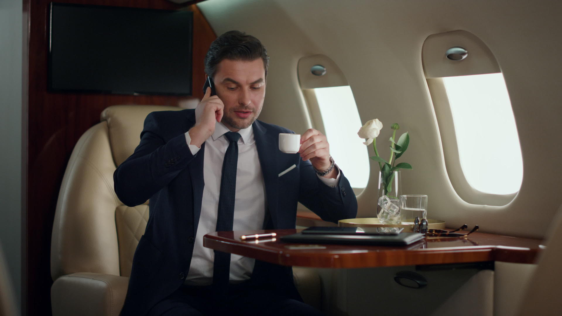 自信的男性白领在飞机上打电话会议视频的预览图