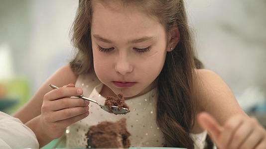 漂亮的女孩吃巧克力蛋糕视频的预览图