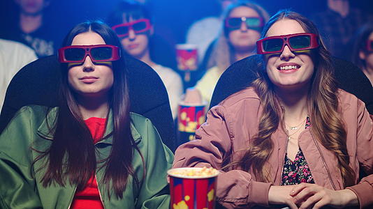 年轻女孩在电影院带了3个女孩d观看眼镜震撼特效视频的预览图