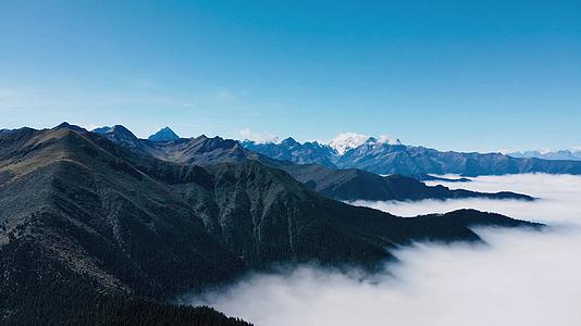4K航拍藏区云海之上的山脉和远处雪山自然风光视频的预览图
