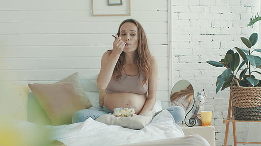 怀孕的妈妈在家休息吃早餐视频的预览图
