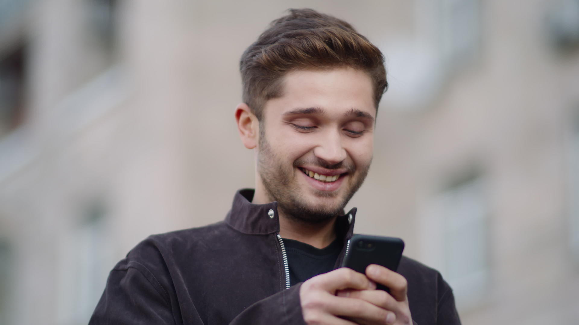 男性在户外阅读手机信息时表情愉快视频的预览图