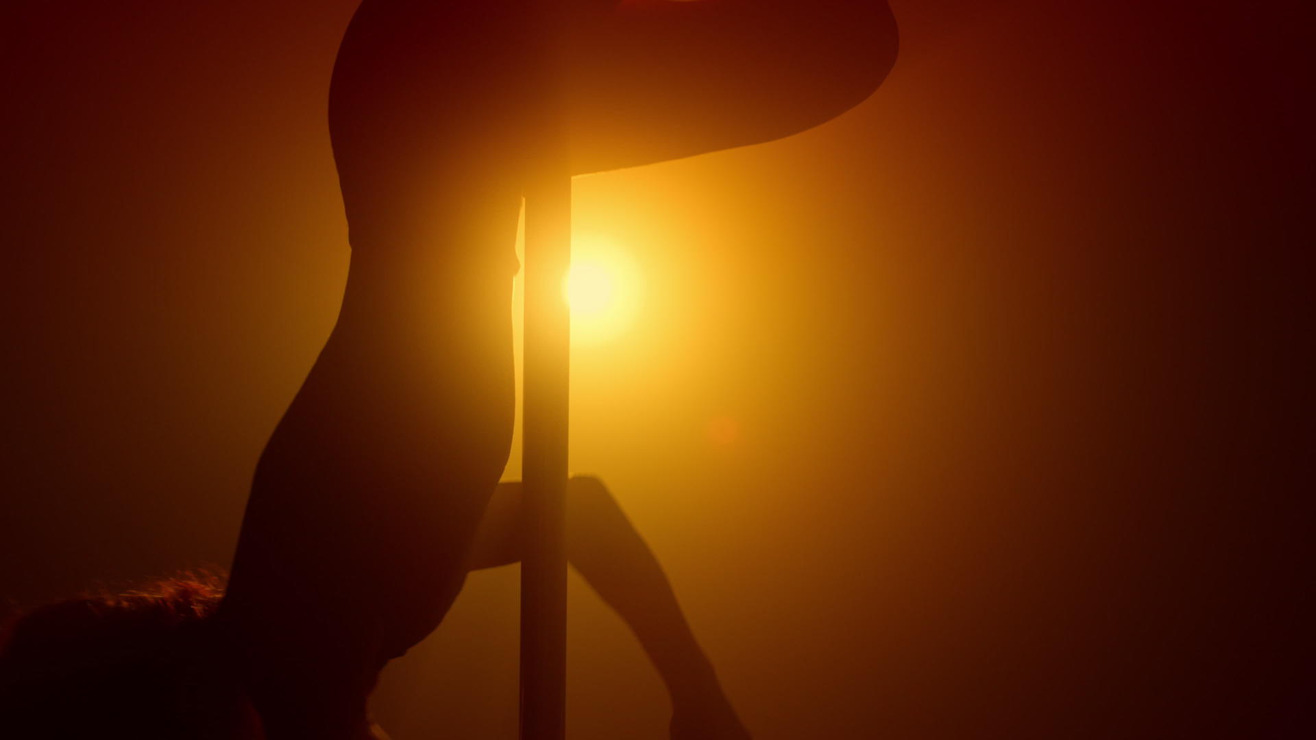 剪影钢管舞女舞者在聚光灯下表演视频的预览图