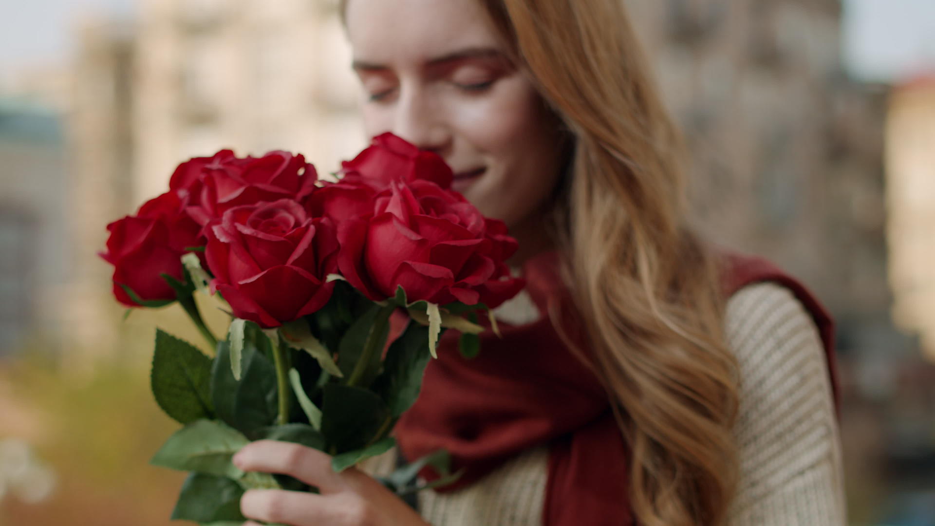 美女在户外街头约会手捧玫瑰闻花香表情幸福视频的预览图