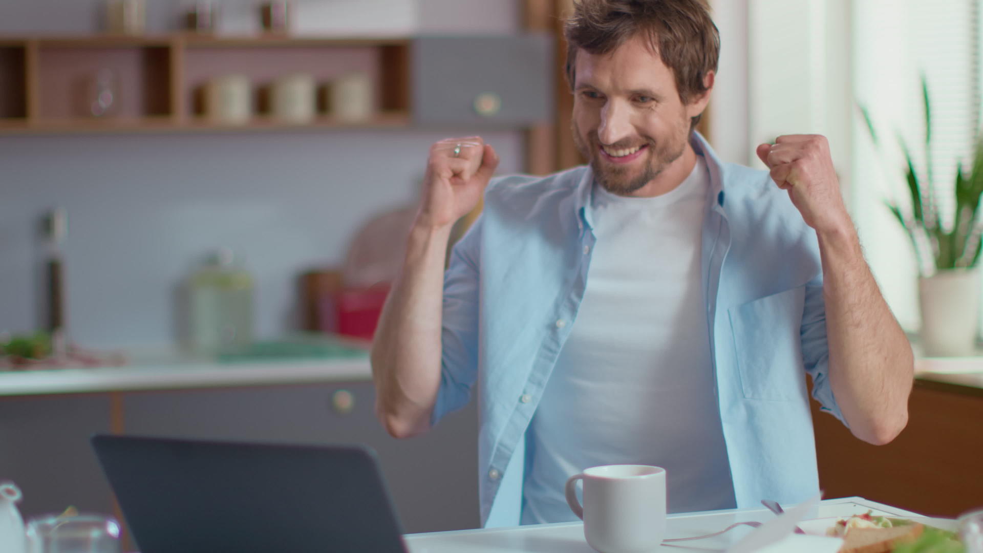 男人在家里看电脑信息表情很开心视频的预览图