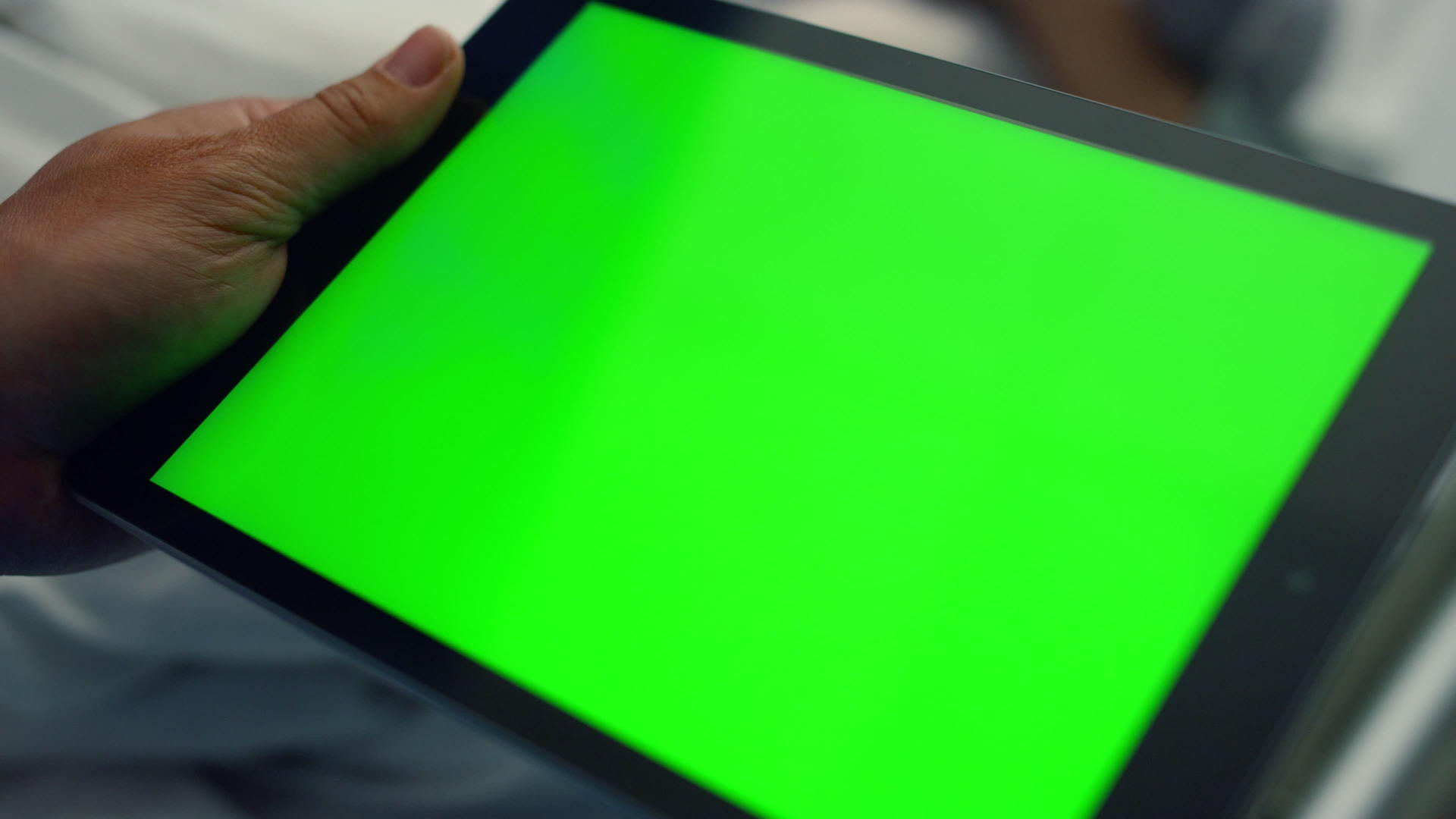 男子手持绿屏平板电脑特写视频的预览图
