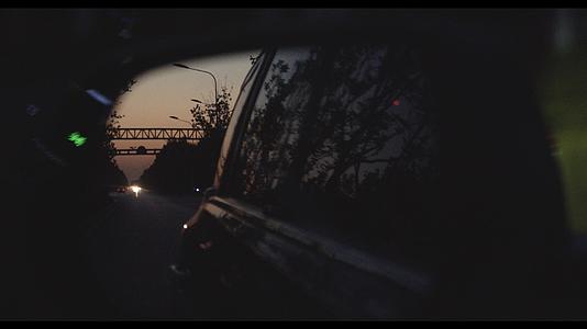 汽车后视镜中投射的黄昏城市景象升格视频的预览图