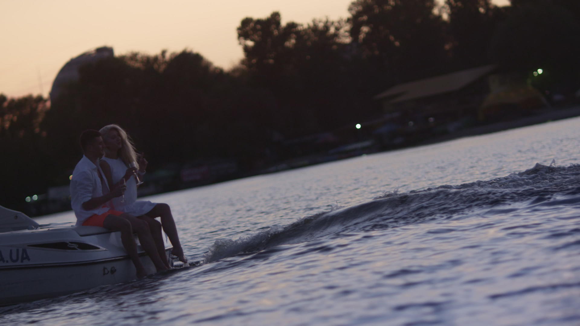 年轻人日落时坐在漂浮的机动船上视频的预览图