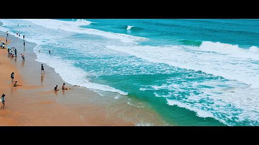 航拍夏日三亚亚龙湾沙滩海滩游客游玩海浪视频的预览图