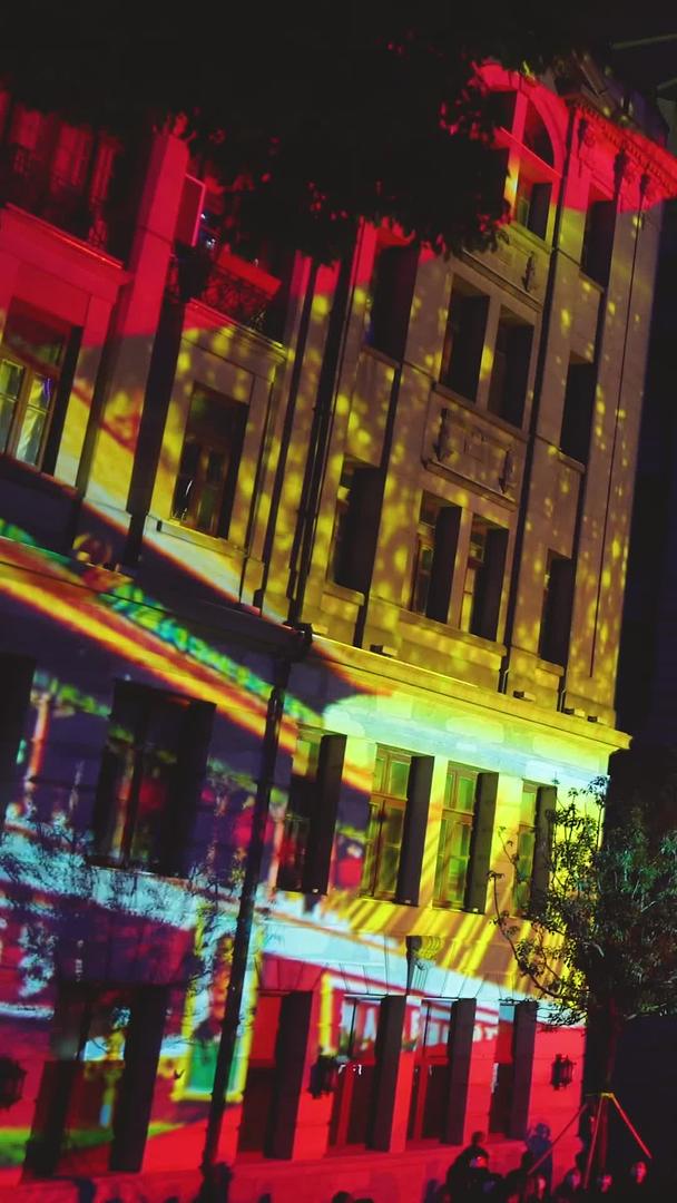夜间城市街景观看公益宣传灯光秀表演的人群素材视频的预览图