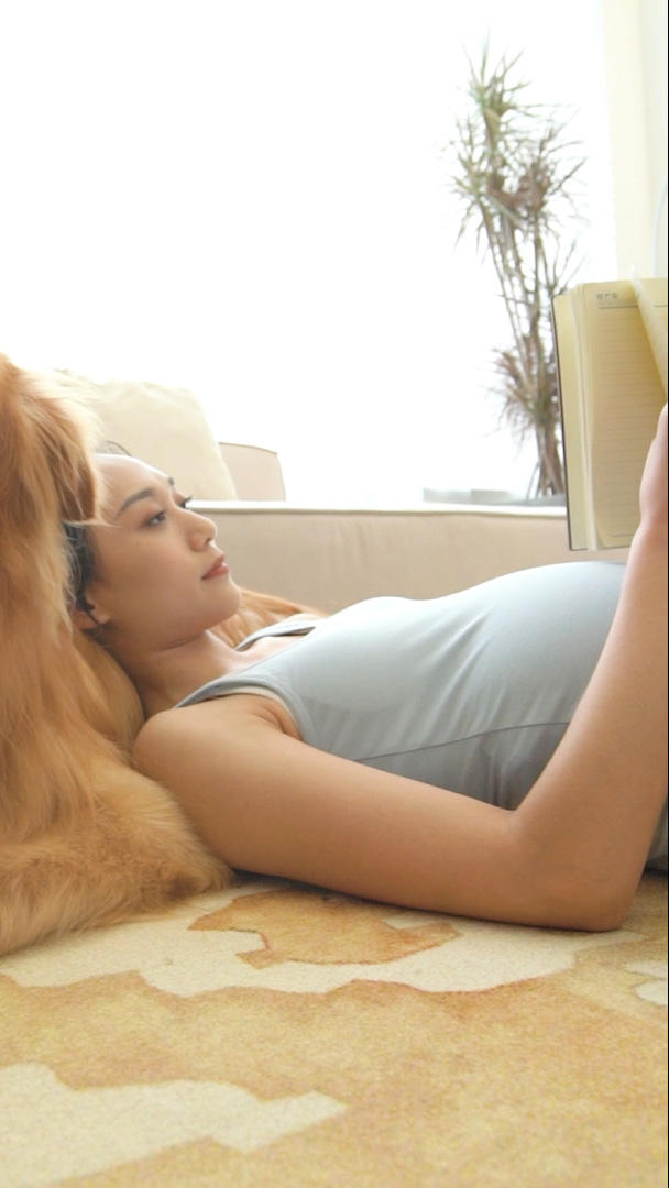 狗狗和孕妇悠闲的躺在客厅视频的预览图