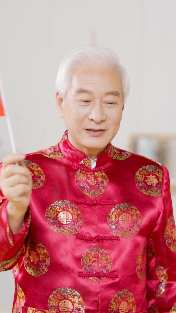 穿中国装扮的爷爷挥舞红旗视频的预览图