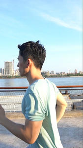 男青年沿着江边跑步视频的预览图