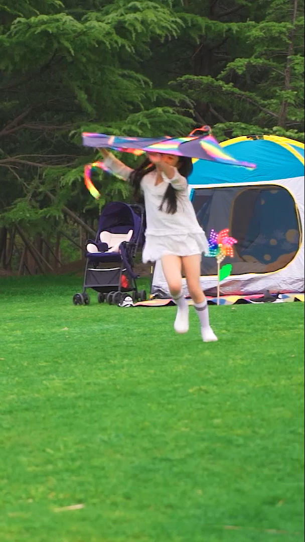 小女孩拿着风筝在草地上跑视频的预览图