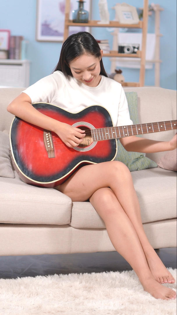 居家女生坐在沙发弹吉他视频的预览图