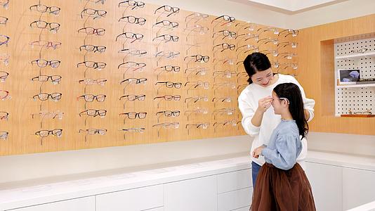 眼镜店里的母女挑选眼镜款式视频的预览图