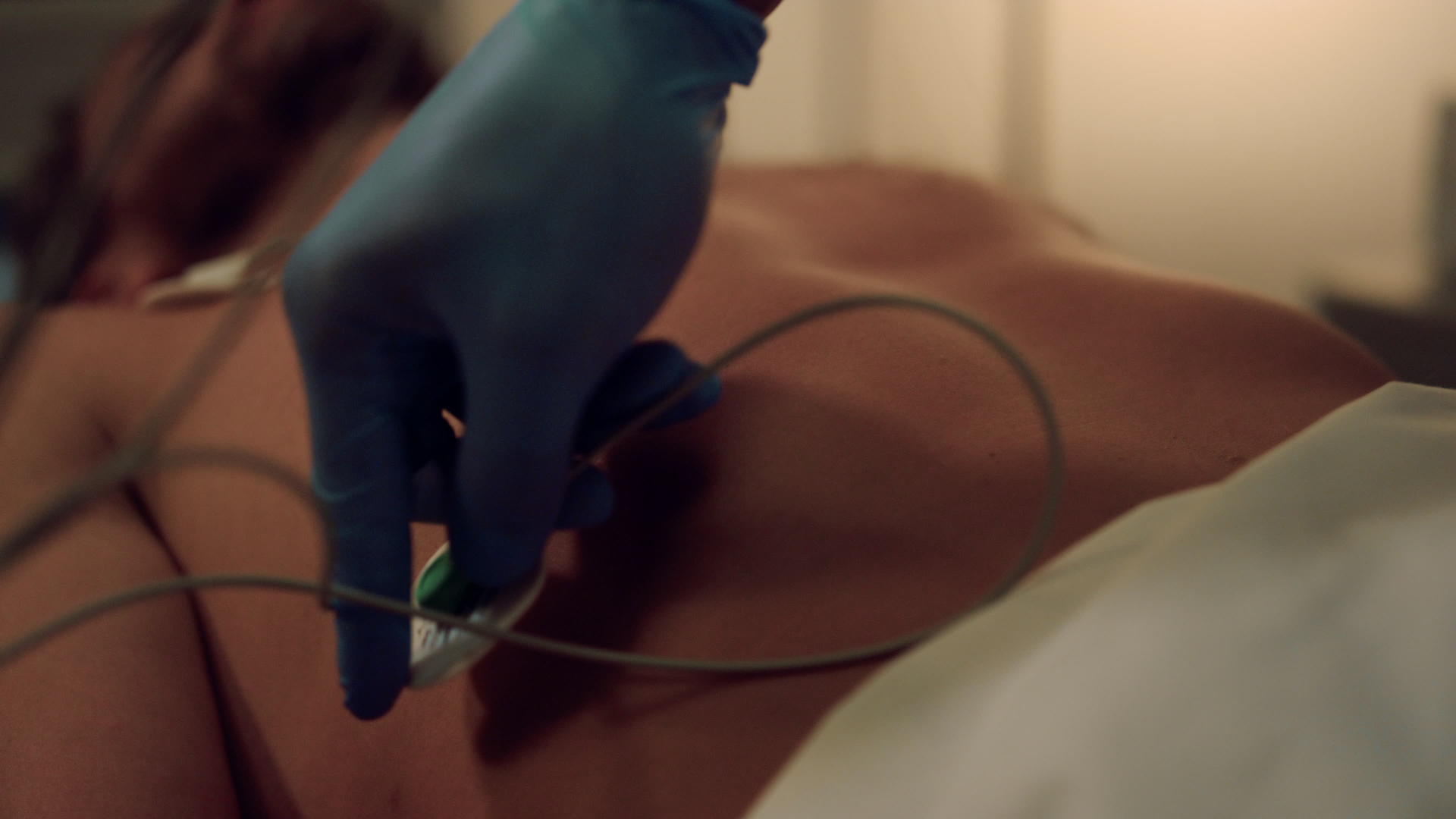 心脏病专家将传感器放在患者的皮肤上准备心脏心电图视频的预览图