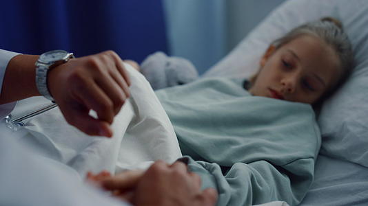 医生检查躺在病床上的小女孩的身体状况视频的预览图