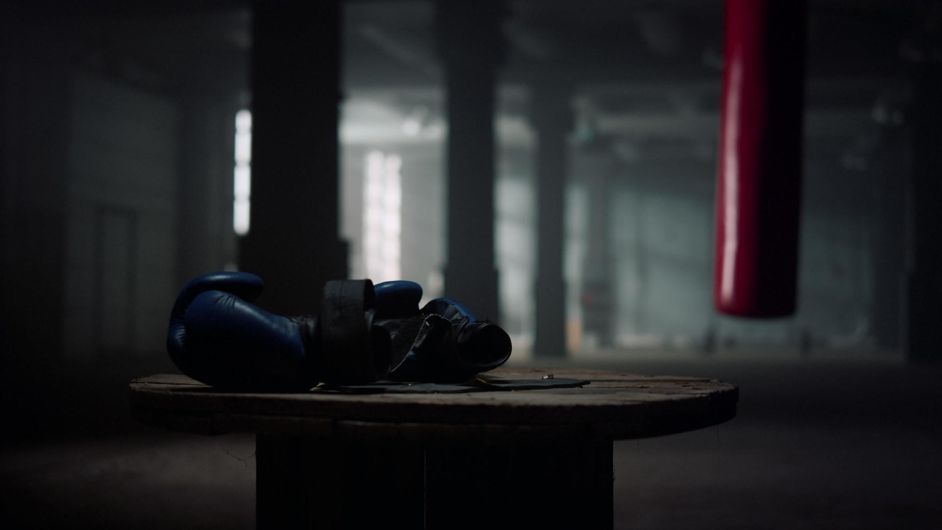 蓝色拳击手套躺在健身房的木箱上视频的预览图