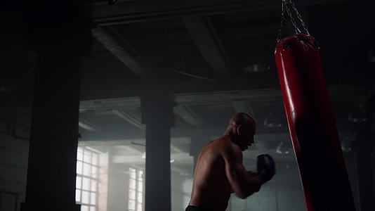 男拳击手在体育俱乐部打运动包视频的预览图
