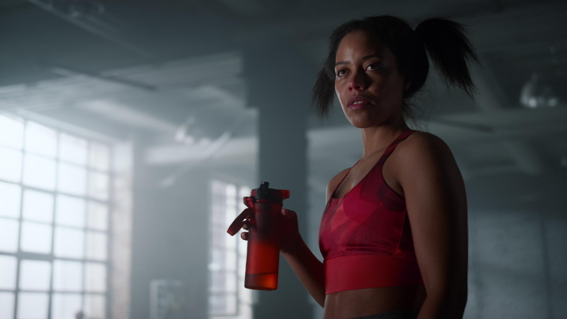 疲惫的女运动员拿着水瓶站在健身房休息视频的预览图