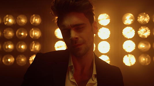 帅气的男模特在灯光下摆出自信的姿态视频的预览图