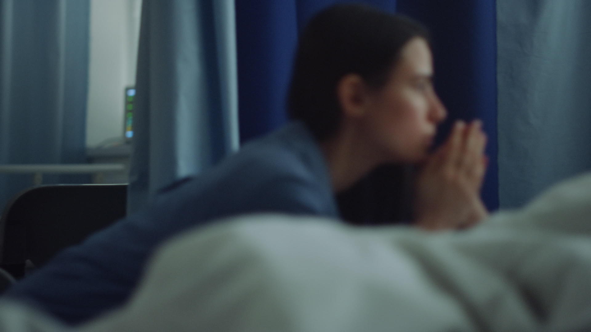 手术后母亲坐在病房里看着生病熟睡的女儿视频的预览图