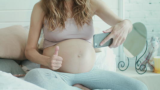 孕妇指着肚子点赞视频的预览图