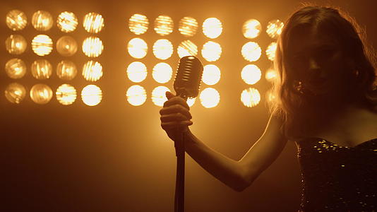性感的女歌手拿着麦克风准备在舞台上独唱视频的预览图